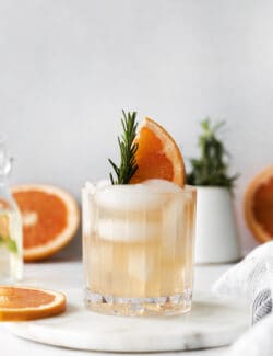 A grapefruit cocktail with rosemary in a glass