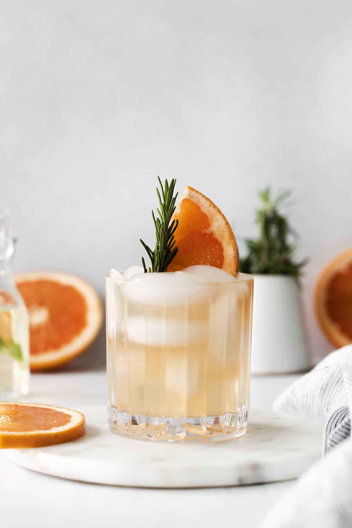 A grapefruit cocktail with rosemary in a glass
