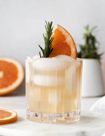 A rosemary greyhound cocktail garnished with fresh rosemary and grapefruit