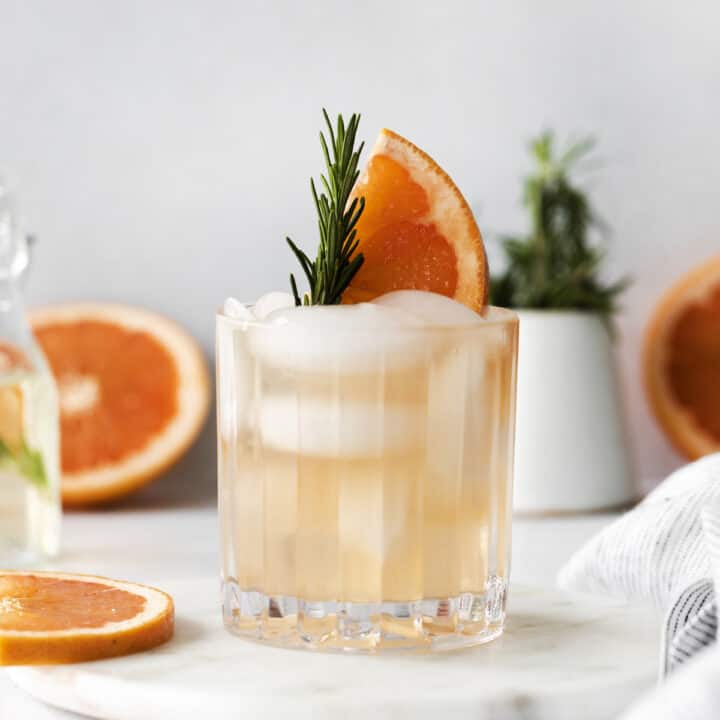 A rosemary greyhound cocktail garnished with fresh rosemary and grapefruit