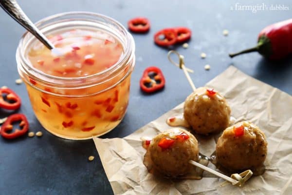 a jar of sweet chili sauce, plus chicken meatballs dipped in the sauce