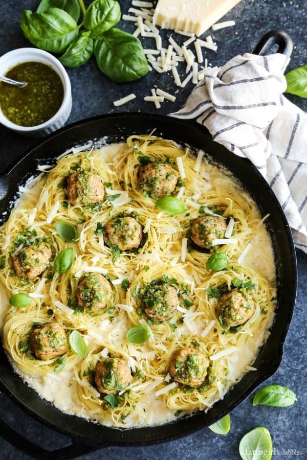 Creamy Garlic Pasta Nests with Pesto Chicken Meatballs in a cast iron skillet