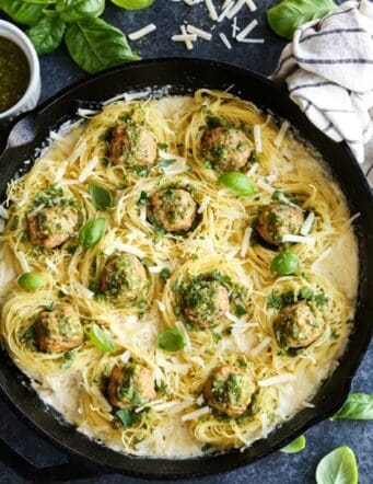 Top view of meatballs in pasta nests with creamy sauce in a cast-iron skillet