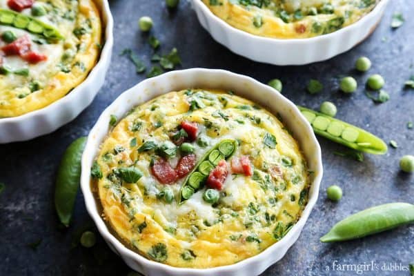 A ramekin of baked scrambled egg mixture with snap peas, pancetta, cheese and herbs