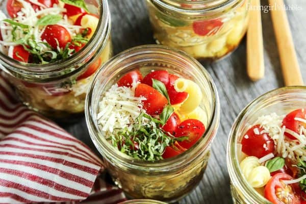 Individual Caprese Pasta Salads on a wooden table