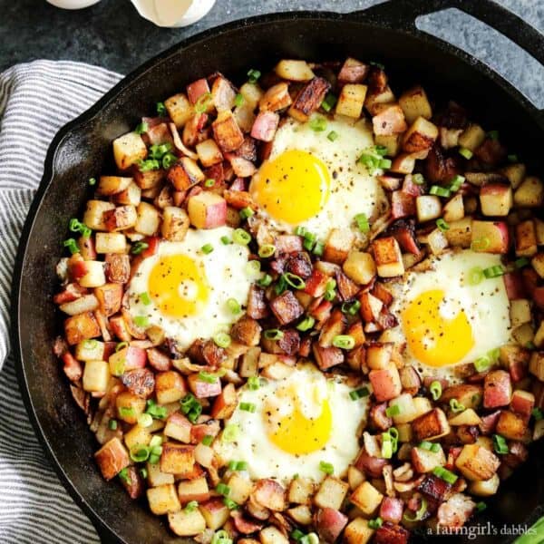 Fried Potato Hash with Bacon and Eggs in a cast iron skillet