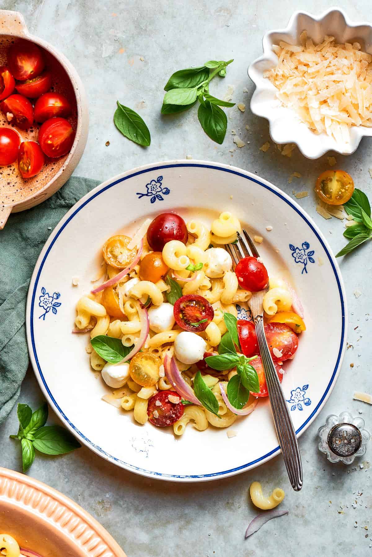 Cavatappi is tossed with juicy tomatoes, creamy mozzarella, basil, Parmesan and a bright balsamic dressing in this fresh caprese pasta salad. Caprese pasta salad in bowl.