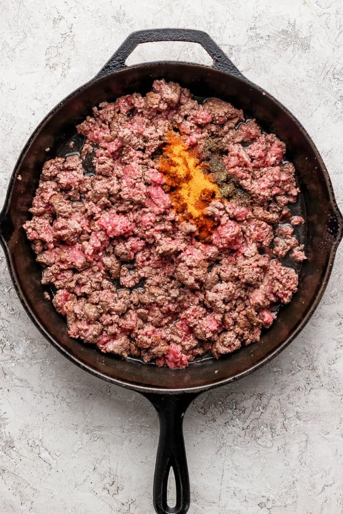 Seasonings added to skillet of ground beef.