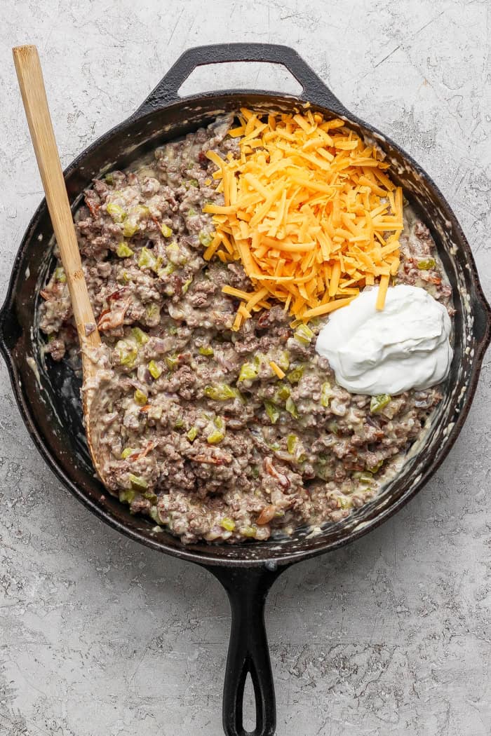Sour cream and cheddar added to skillet of creamy ground beef.