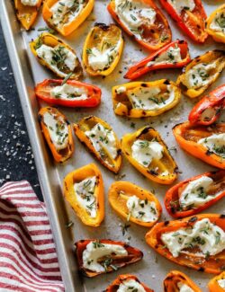 grilled mini sweet peppers with goat cheese on a baking dish