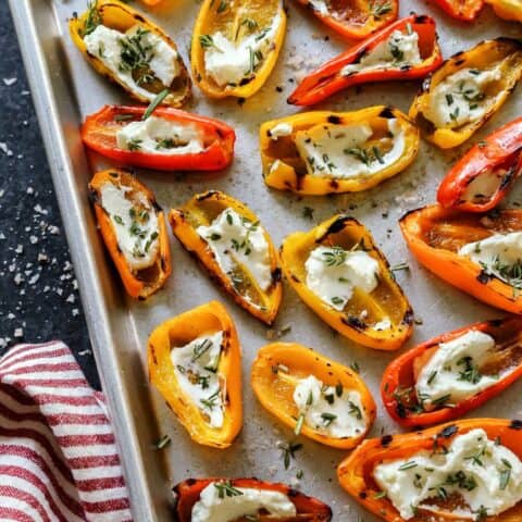 grilled mini sweet peppers with goat cheese on a baking dish