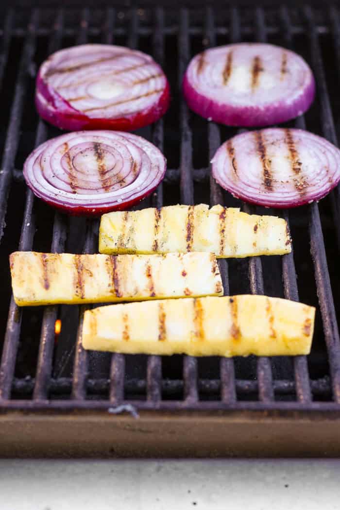 Pineapple spears and red onion rounds on grill