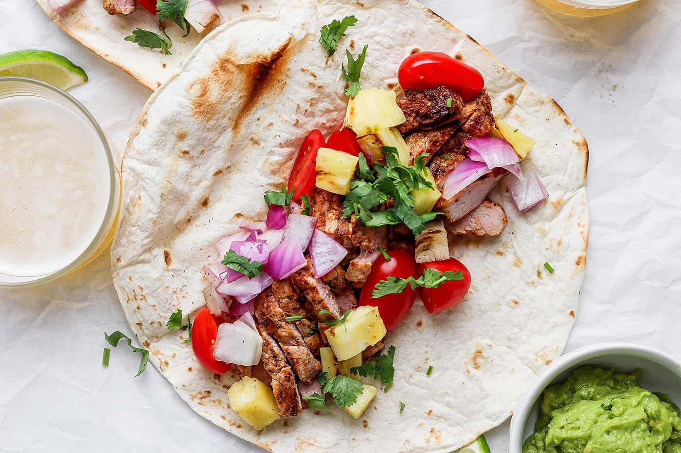 Overhead view of grilled pork and pineapple taco before folding