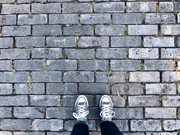feet on a cobblestone sidewalk