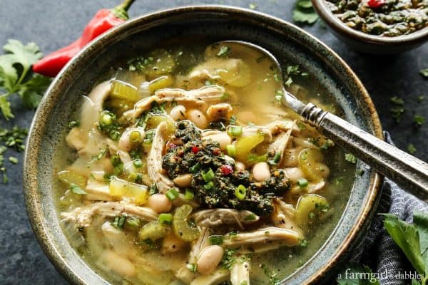 Chicken Chimichurri Soup with White Beans in a pottery bowl with spoon