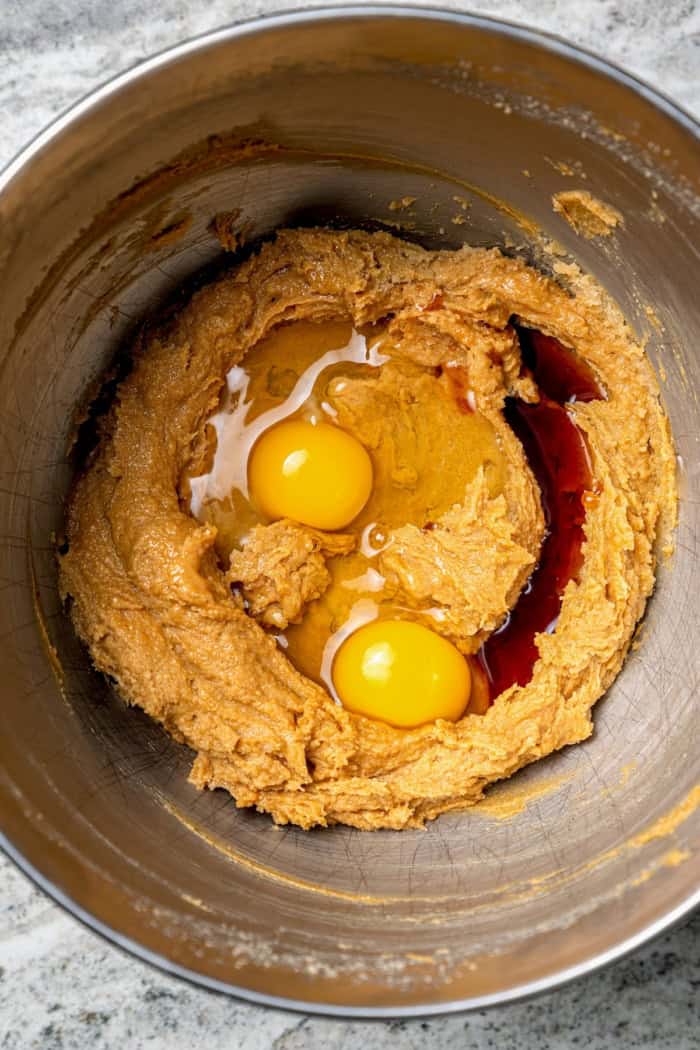 Eggs and vanilla added to bowl of creamed butter and sugar.