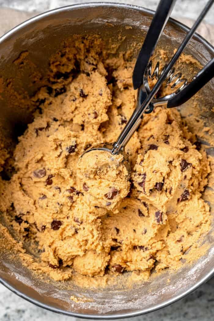 Cookie dough scoop scooping peanut butter chocolate chip cookie dough.