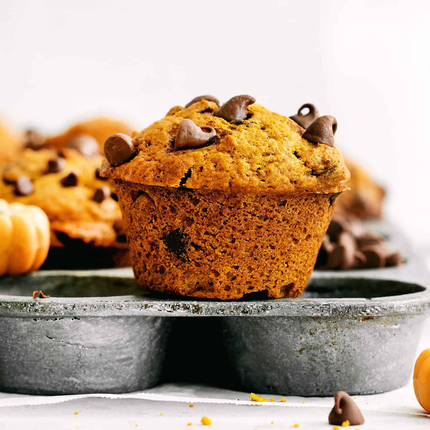 A pumpkin muffin sitting on top of a muffin pan