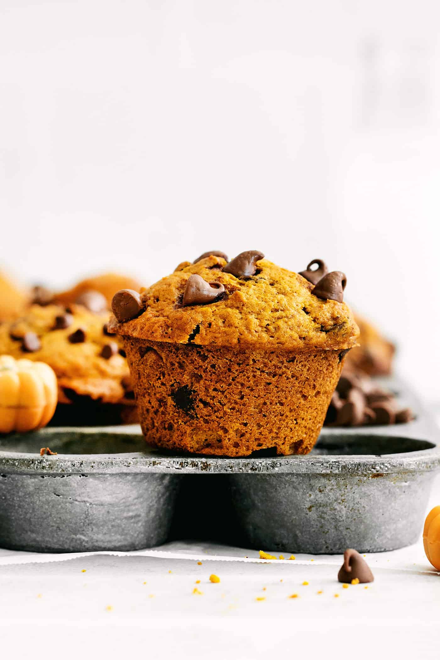 A pumpkin muffin on top of a muffin pan
