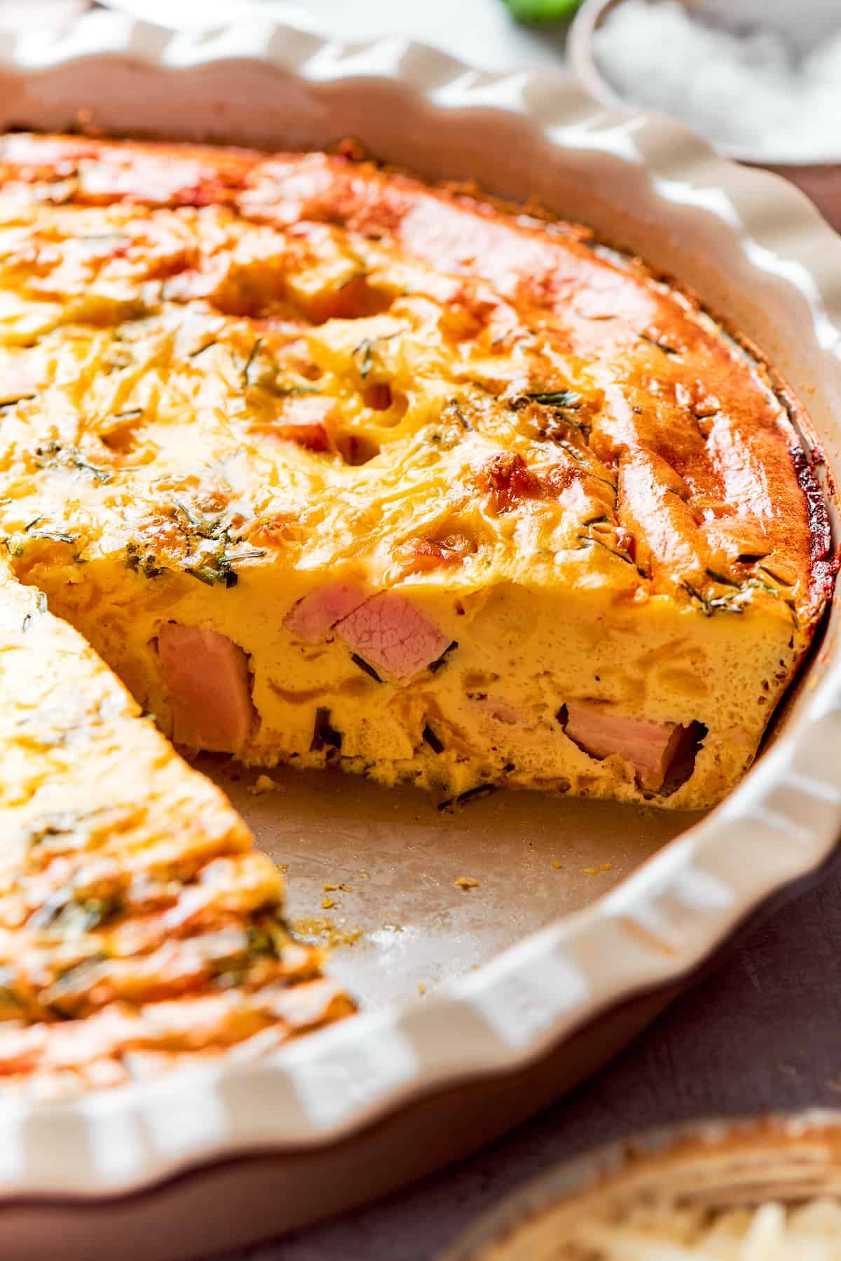Side-shot of the fluffy, baked quiche in the pie dish.
