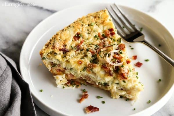 a slice of Herby Crustless Quiche with Crab and Bacon on a white plate