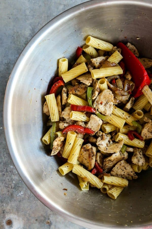 pasta, chicken, peppers, and onions in stainless steel bowl