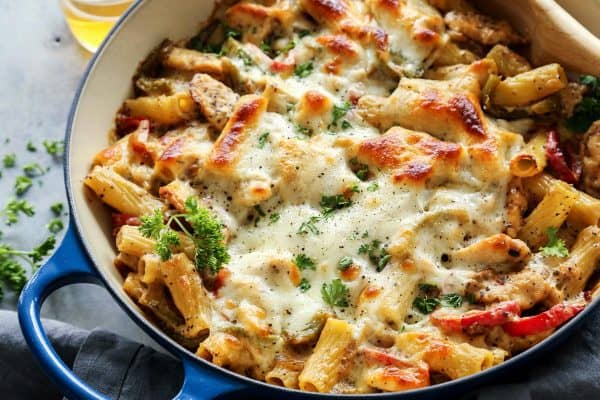 Chicken Cheesesteak Baked Ziti in blue dish, with wooden spoon