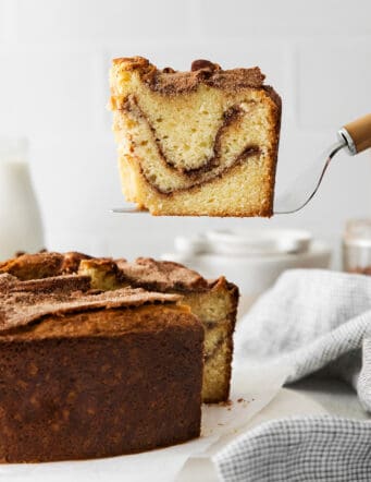 A spatula serving a slice of sour cream coffee cake with cinnamon ripple