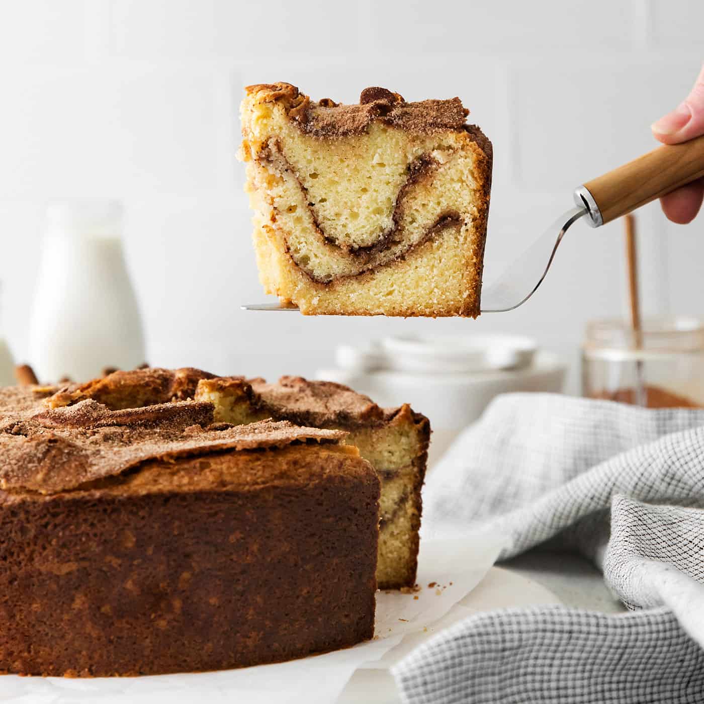 A spatula serving a slice of sour cream coffee cake with cinnamon ripple