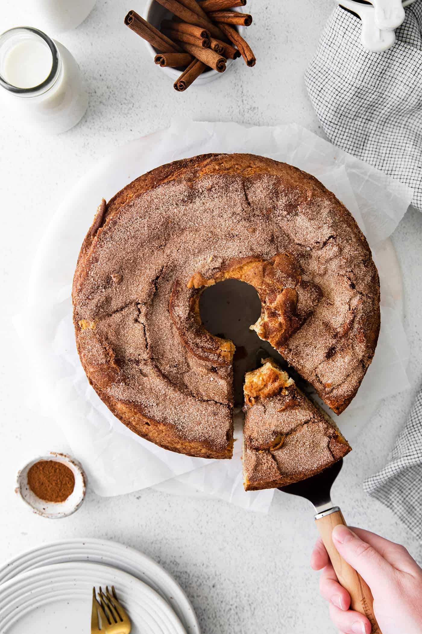 Overhead view of a slice being served from a coffee cake with cinnamon ripple