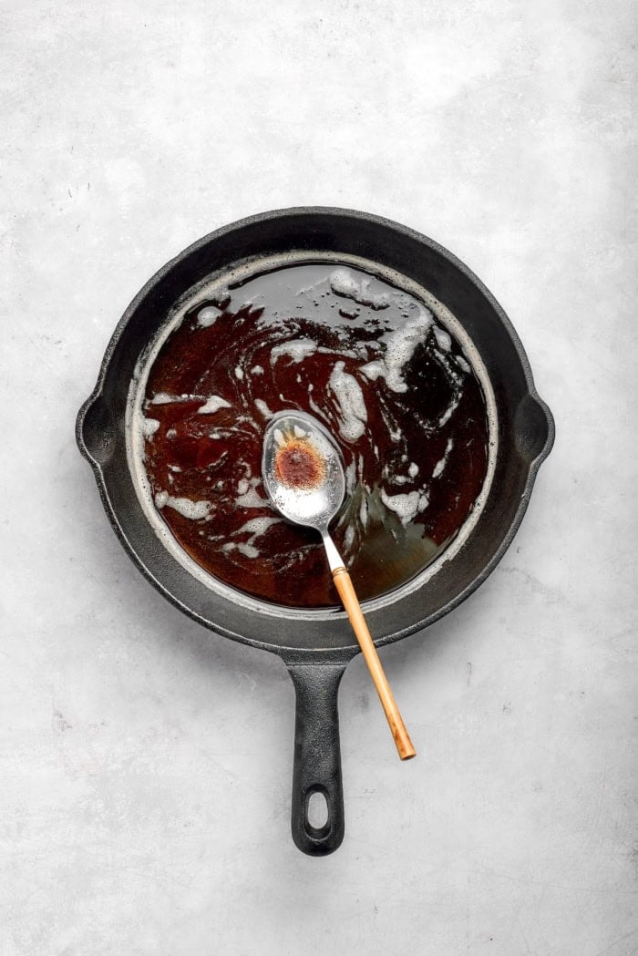 Brown butter in skillet with spoon.