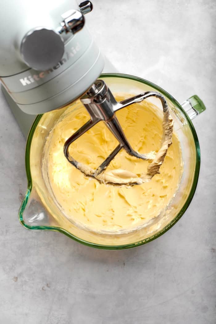 Butter in bowl of stand mixer fitted with paddle attachment.