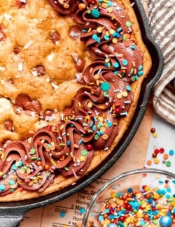Brown butter chocolate chip skillet cookie decorated with chocolate buttercream and sprinkles.
