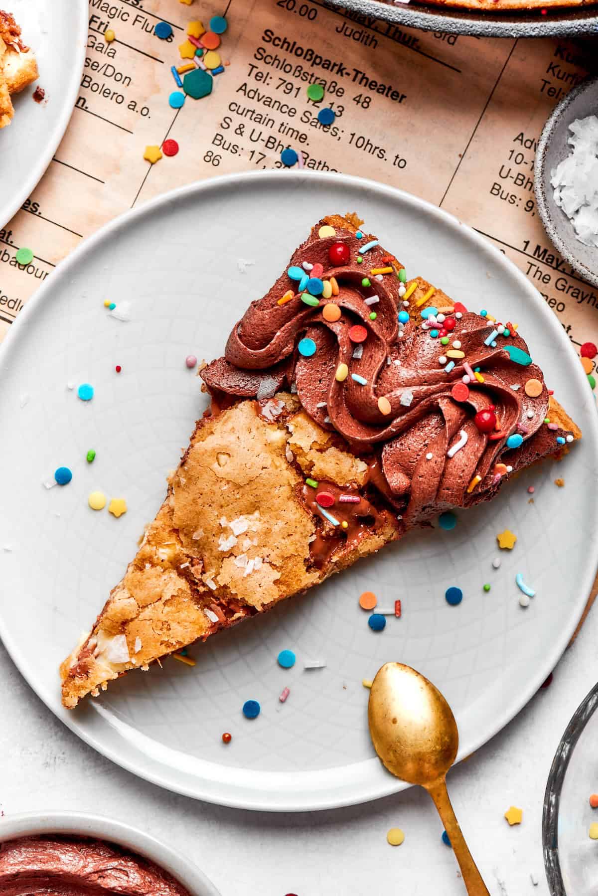 Brown butter chocolate chip skillet cookie slice on plate with sprinkles.