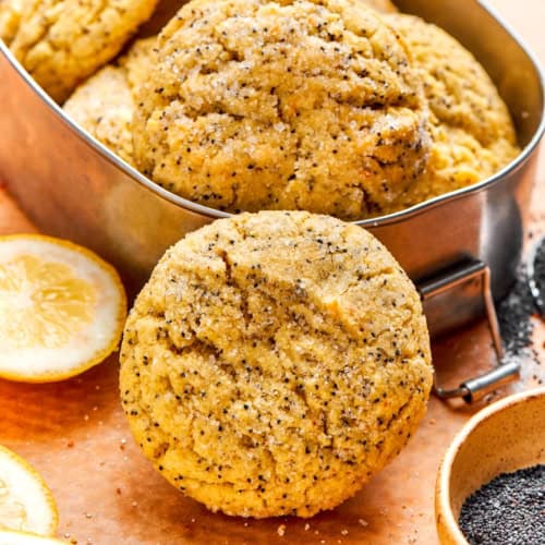 Orange and lemon poppy seed cookie set against tin.