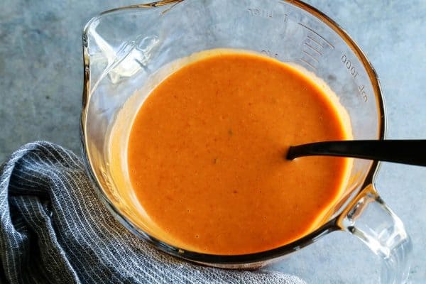 mixing creamy taco salad dressing in a clear bowl with spout