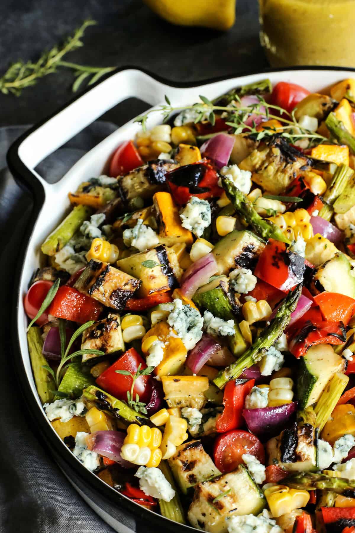 Summer vegetable salad in pan with blue cheese crumbles