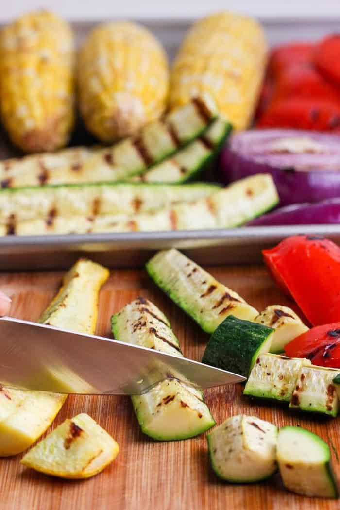 Slicing grilled zucchini on cutting board