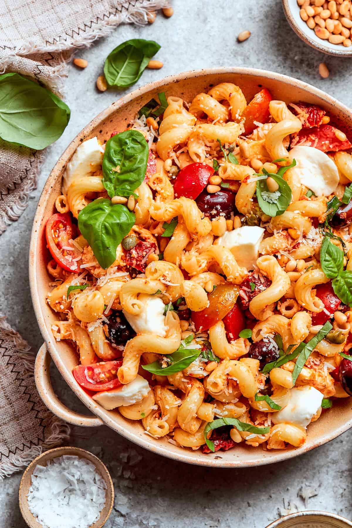 This sun-dried tomato pasta salad lets the abundance of summer produce shine, with juicy tomatoes and fresh basil. Perfect for picnics! Serving bowl of sun-dried tomato pasta salad.
