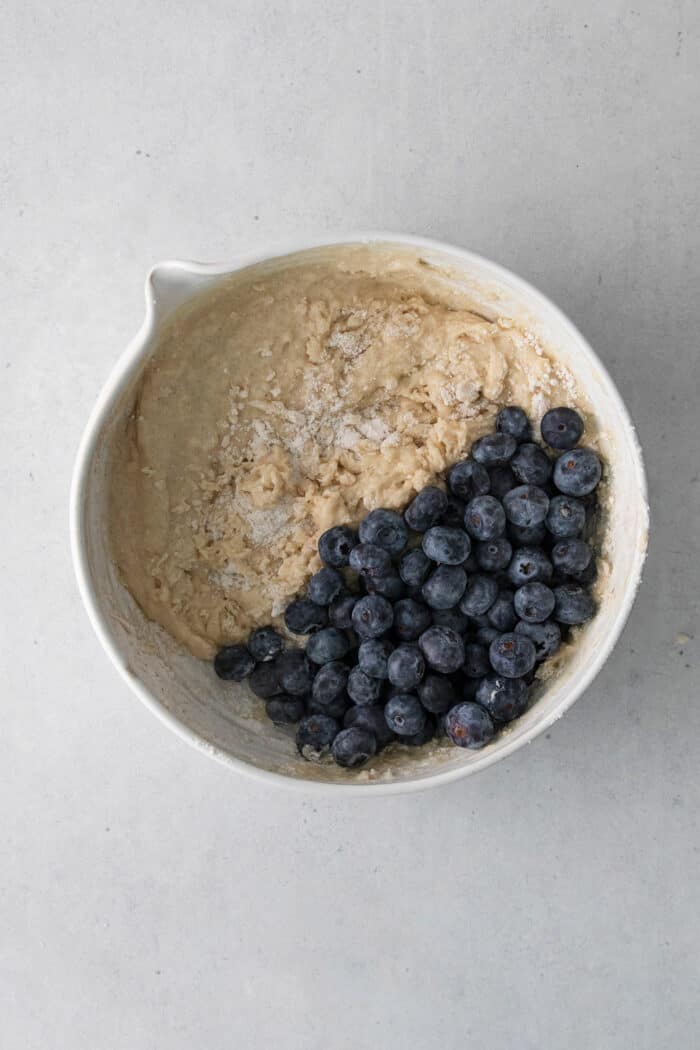 Muffin batter with blueberries in a mixing dish