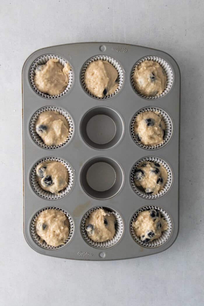 Blueberry muffin batter in a muffin tin