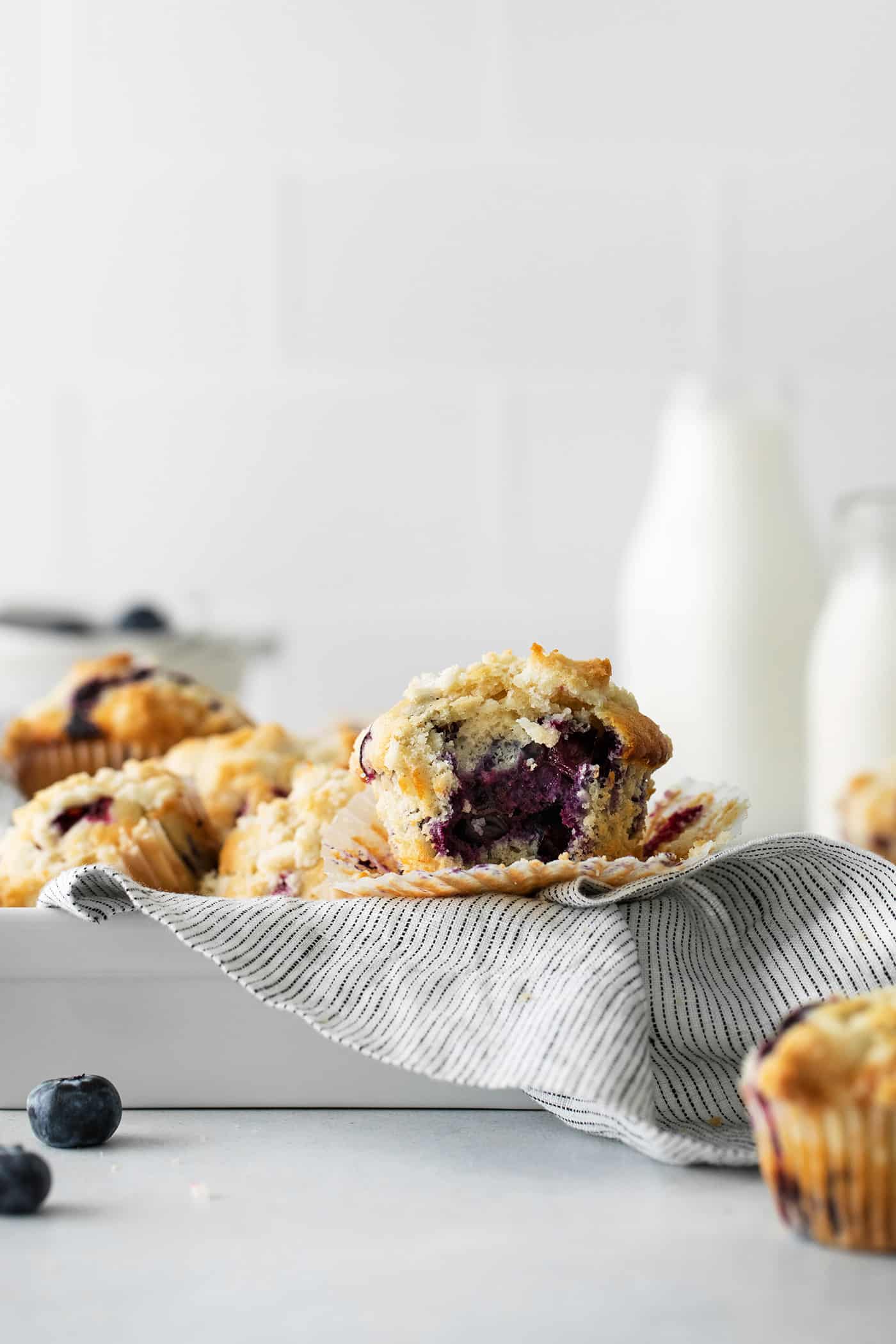 Blueberry muffins in a metal pan for serving with one cut in half