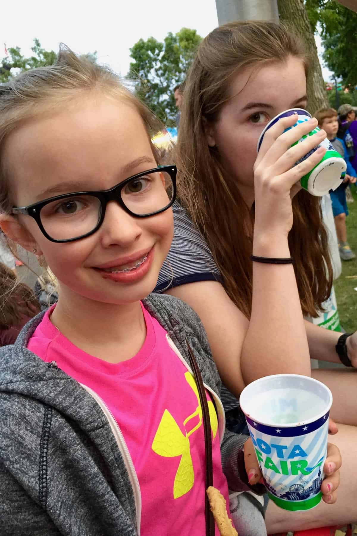 2 girls drinking glasses of milk