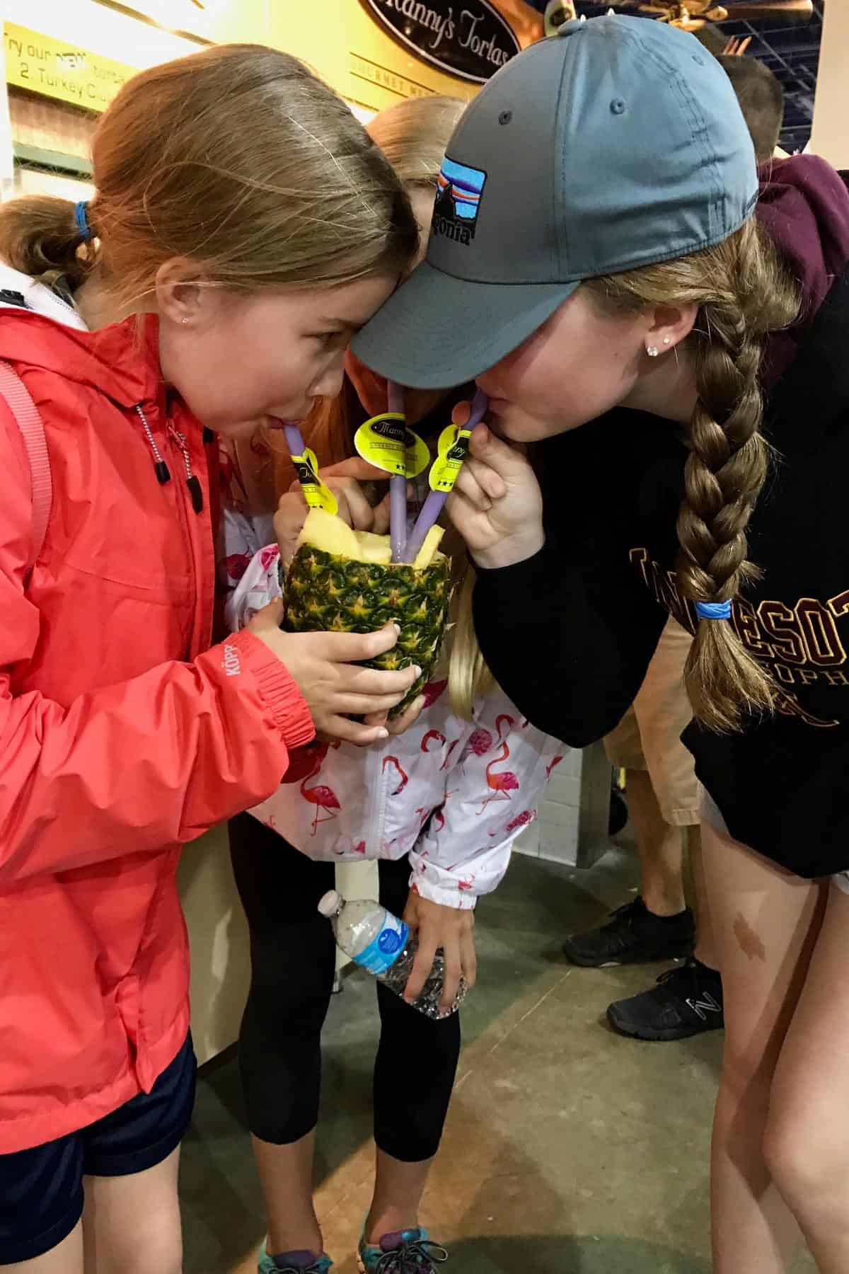 3 girls sharing a pina colada drink