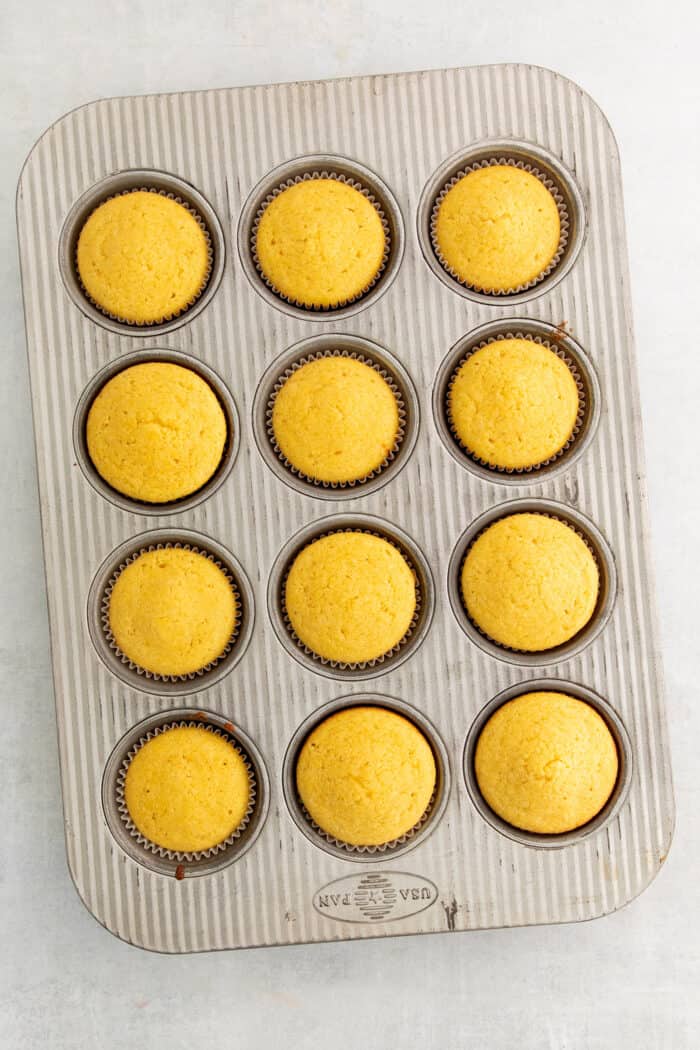 Freshly-baked, golden muffins in the muffin tray. 