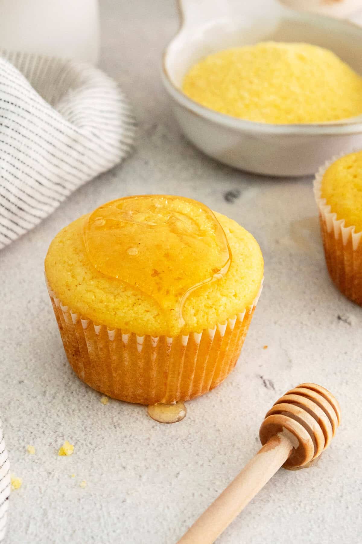 Close-up of a fluffy cornbread muffin with a cupcake liner.