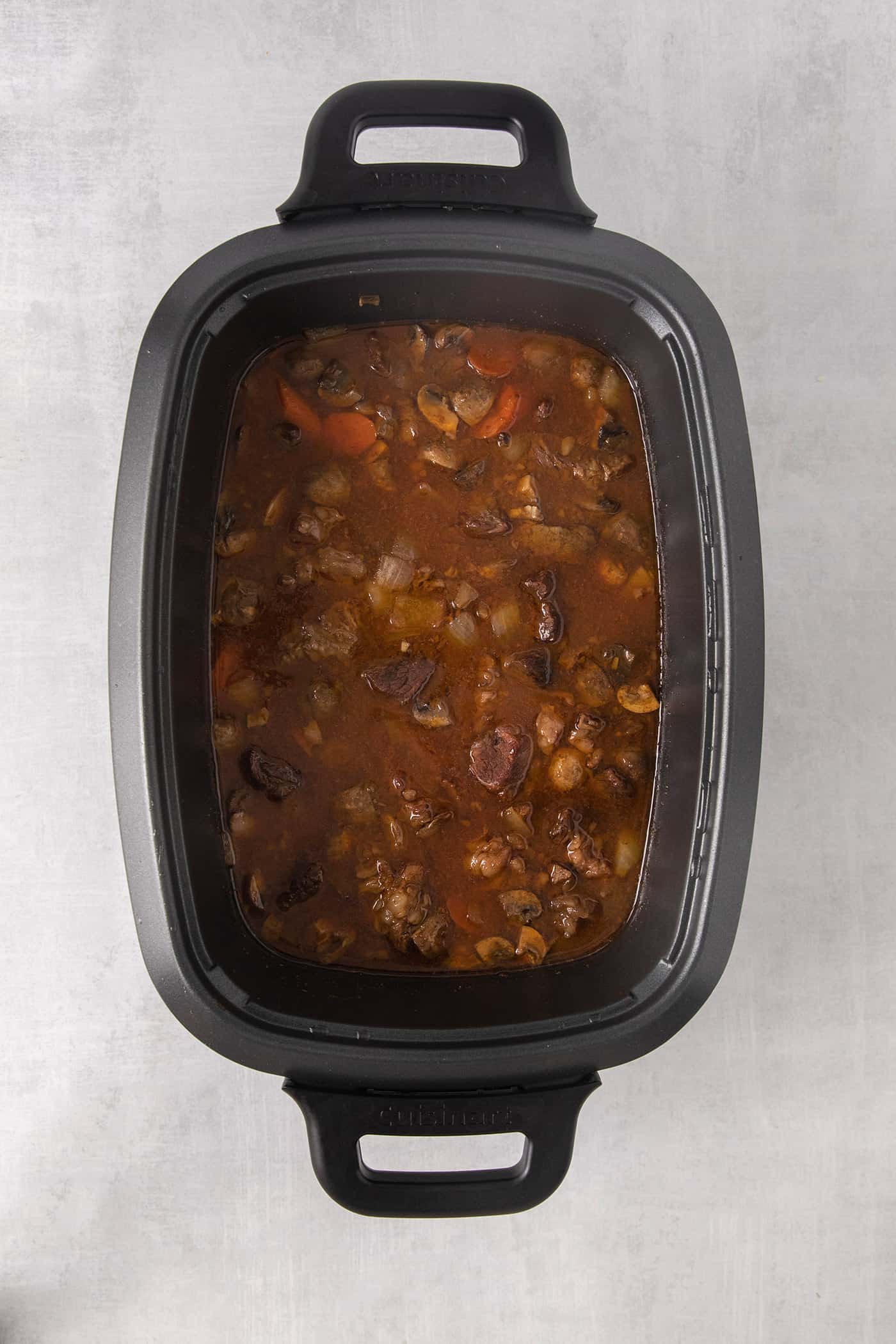 A spoon over a bowl of goulash