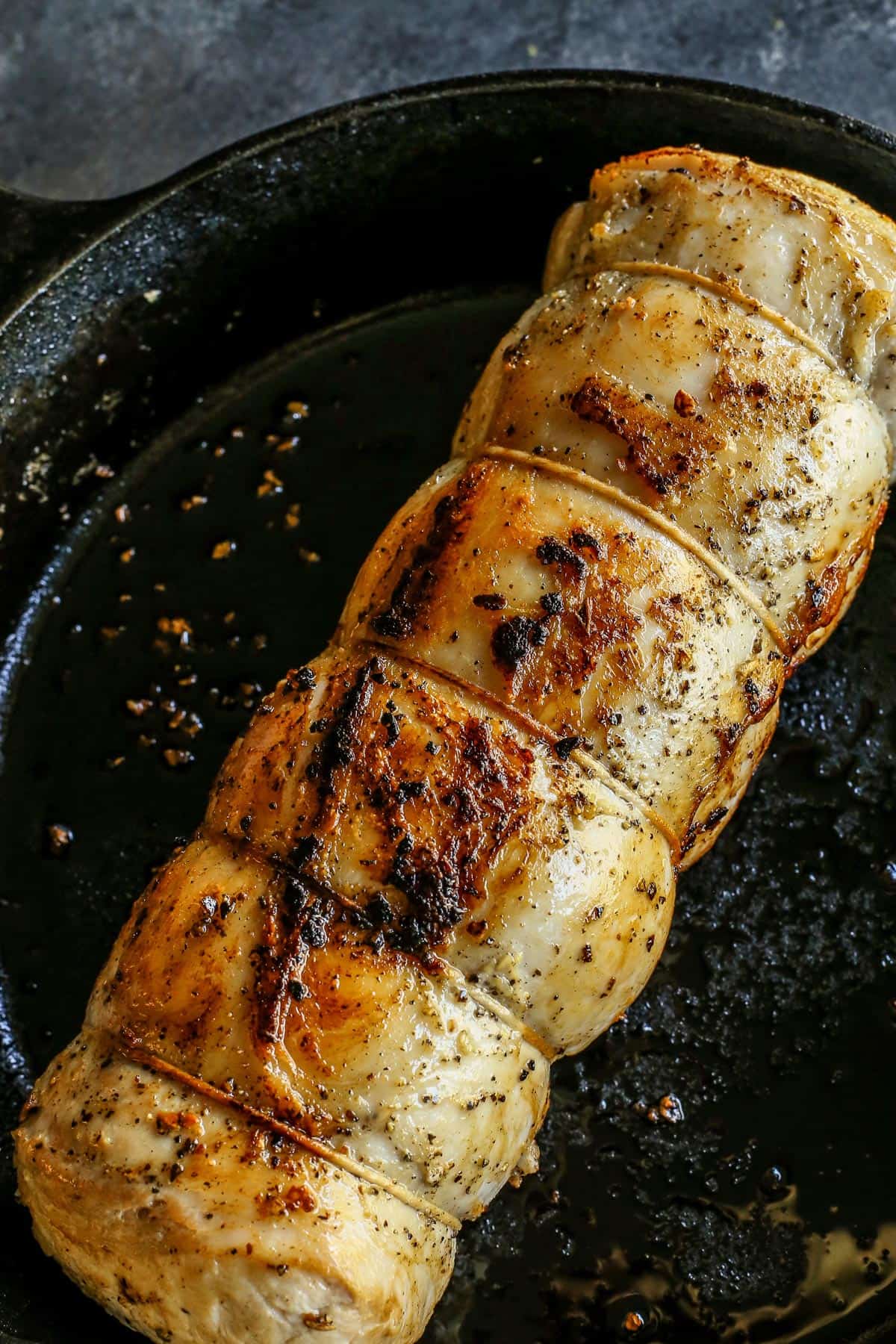 A pork loin roast in a cast iron skillet