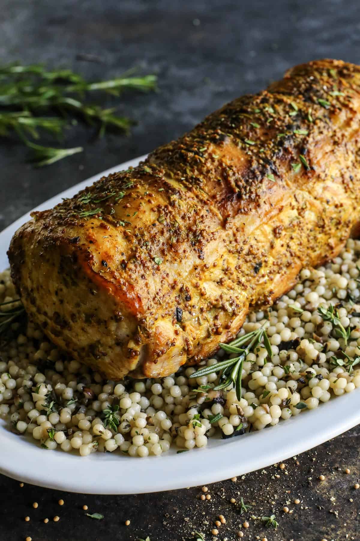 A mustard pork loin roast over a bed of couscous