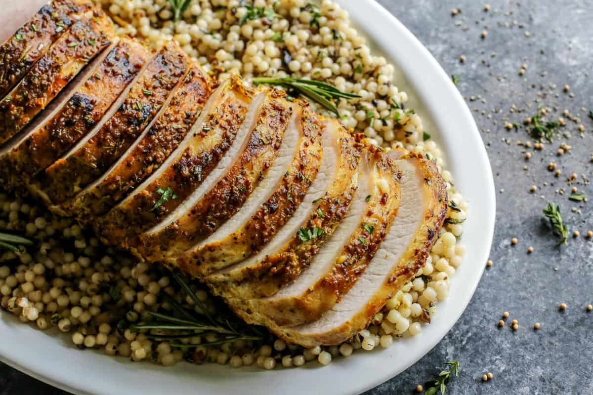 Sliced mustard pork loin roast over a bed of couscous